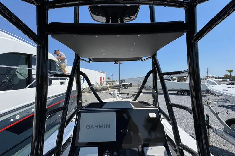 Slide: The Image of 2025 BlackJack 256 Coastal boat interior with Garmin navigation system, docked at a marina. - 27