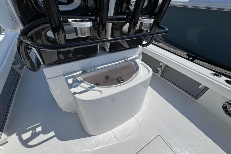 Slide: The Image of 2025 BlackJack 256 Coastal boat interior with rod holders and storage compartment. - 30