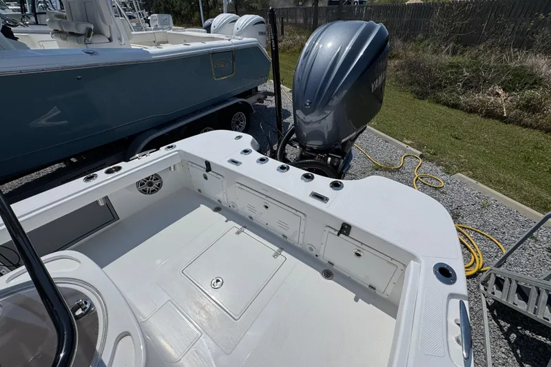 Slide: The Image of 2025 BlackJack 256 Coastal boat with Yamaha outboard engine, docked on gravel. - 32