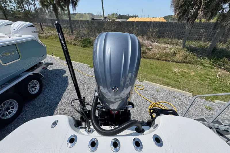 Slide: The Image of 2025 BlackJack 256 Coastal boat with Yamaha outboard engine, parked on gravel. - 34