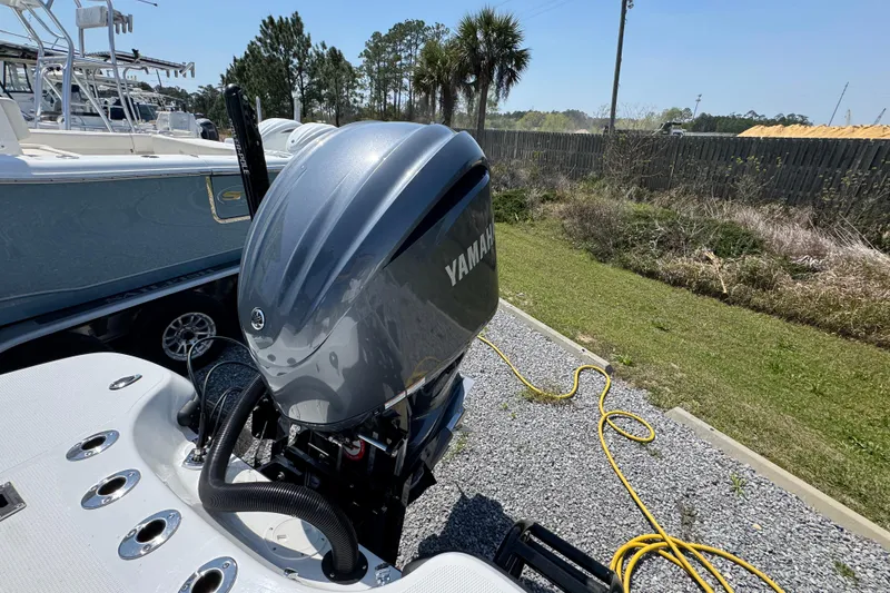 Slide: The Image of 2025 BlackJack 256 Coastal boat with Yamaha outboard motor, parked on gravel. - 35