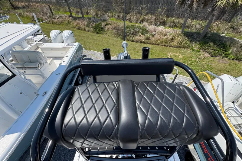 Slide: The Image of BlackJack 256 Coastal 2025 boat with diamond-stitched black leather seating, docked outdoors. - 37