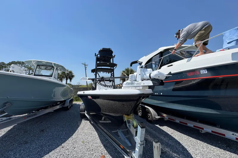 Slide: The Image of 2025 BlackJack 256 Coastal boat on trailer, parked between two other boats. - 4