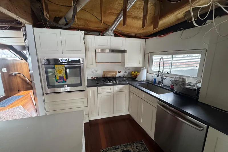 Slide: The Image of Modern kitchen interior on 1997 Tarrab 77 Motor Yacht with sleek appliances and wooden flooring. - 15