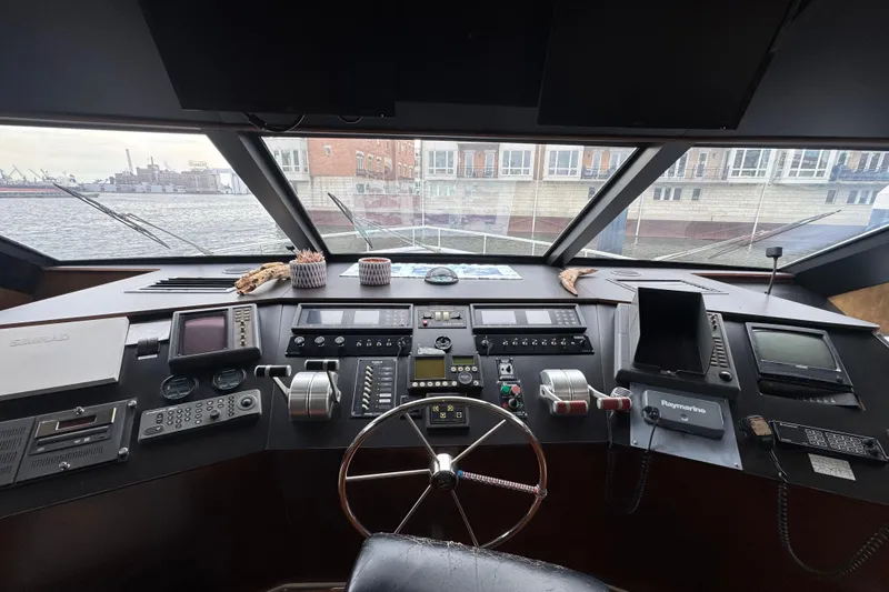 Slide: The Image of Cockpit view of 1997 Tarrab 77 Motor Yacht with navigation controls and waterfront scenery. - 25