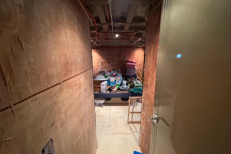 Slide: The Image of Interior of a 1997 Tarrab 77 Motor Yacht with stored items and wooden walls. - 54