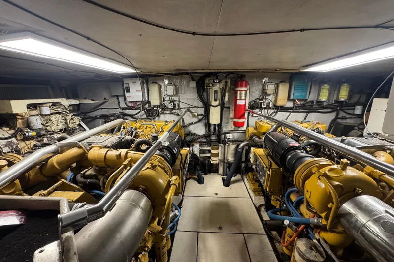 Slide: The Image of Engine room of a 1997 Tarrab 77 Motor Yacht, showcasing complex machinery and wiring. - 65