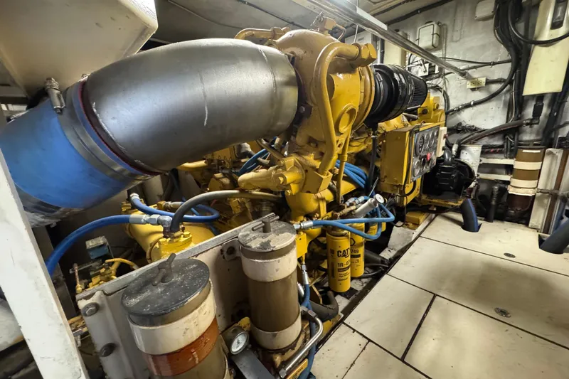 Slide: The Image of Engine room detail of a 1997 Tarrab 77 Motor Yacht, showing mechanical components and hoses. - 68