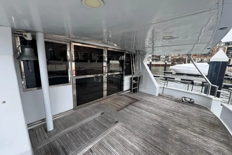 Slide: The Image of Spacious deck of 1997 Tarrab 77 Motor Yacht with wooden flooring and marina view. - 8