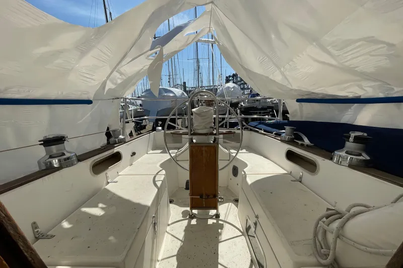 Slide: The Image of 1982 Sabre 34 sailboat deck with winches and ropes, docked in a marina. - 13