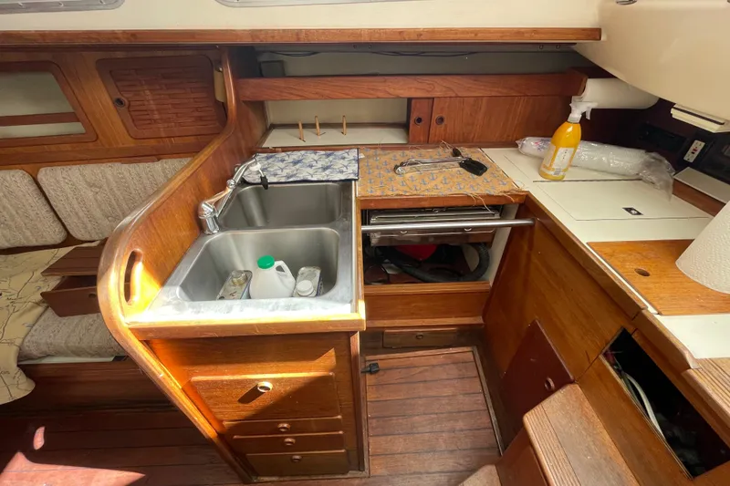 Slide: The Image of 1982 Sabre 34 yacht kitchen with double sink, wooden cabinetry, and ample counter space. - 18