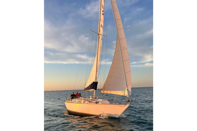 Slide: The Image of 1982 Sabre 34 sailboat gliding on calm ocean waters at sunset. - 2