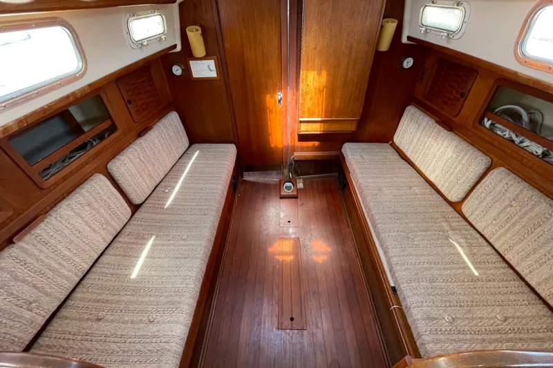 Slide: The Image of Interior of a 1982 Sabre 34 sailboat with wooden paneling and cushioned seating. - 24
