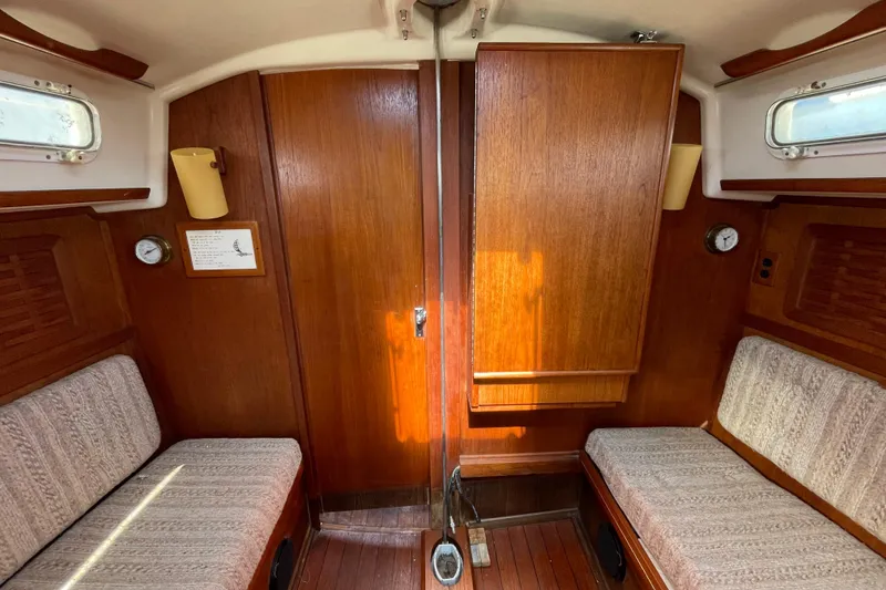 Slide: The Image of Interior of a 1982 Sabre 34 sailboat with wooden paneling and cushioned seating. - 27