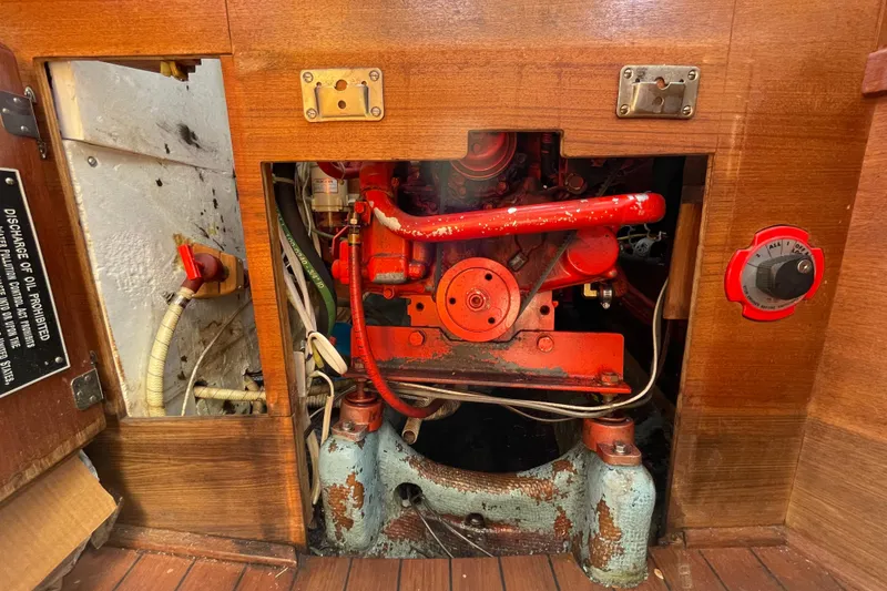 Slide: The Image of Engine compartment of a 1982 Sabre 34 sailboat, featuring red mechanical components. - 31