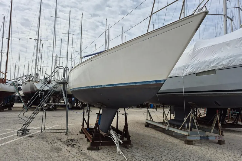 Slide: The Image of 1982 Sabre 34 sailboat on dry dock, surrounded by other boats, under cloudy sky. - 5