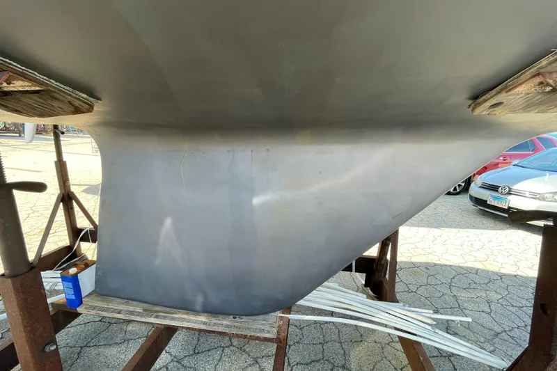 Slide: The Image of Keel of a 1982 Sabre 34 sailboat on a stand, with cars in the background. - 9