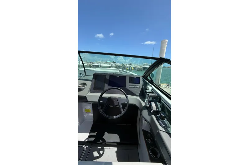 Slide: The Image of 2023 Aviara 32AV boat helm with modern controls and clear blue sky. - 11
