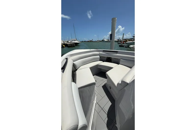 Slide: The Image of 2023 Aviara 32AV boat interior with sleek seating, docked at a marina under clear skies. - 12