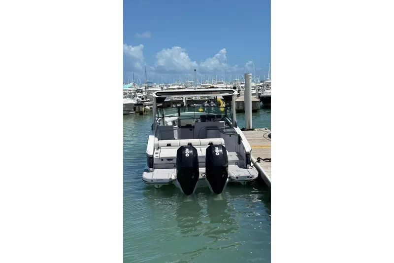 Slide: The Image of 2023 Aviara 32AV boat docked at marina with twin outboard engines. - 2