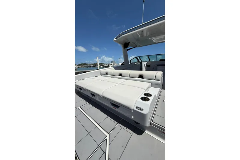 Slide: The Image of 2023 Aviara 32AV boat with luxurious seating and cup holders, docked under clear skies. - 5
