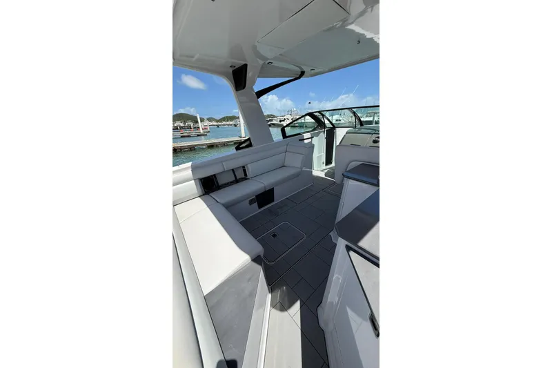 Slide: The Image of 2023 Aviara 32AV boat interior with sleek seating and modern design at a marina. - 8