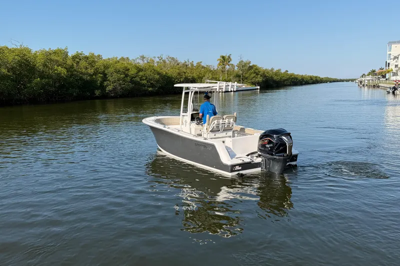 Slide: The Image of 2023 Sportsman Open 232 Center Console boat cruising on a calm waterway. - 12