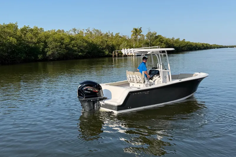 Slide: The Image of 2023 Sportsman Open 232 Center Console boat cruising on a calm river. - 13