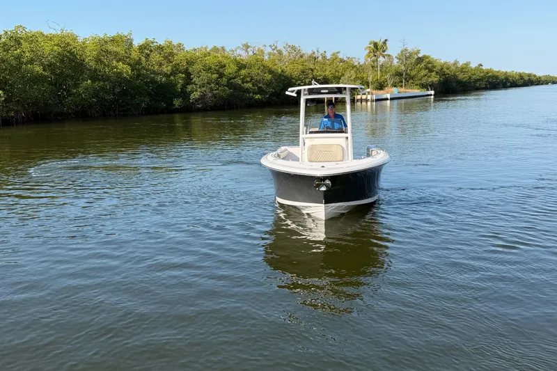 Slide: The Image of 2023 Sportsman Open 232 Center Console boat cruising on a calm waterway. - 15