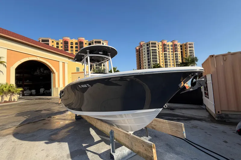 Slide: The Image of 2023 Sportsman Open 232 Center Console boat on display near luxury buildings. - 2