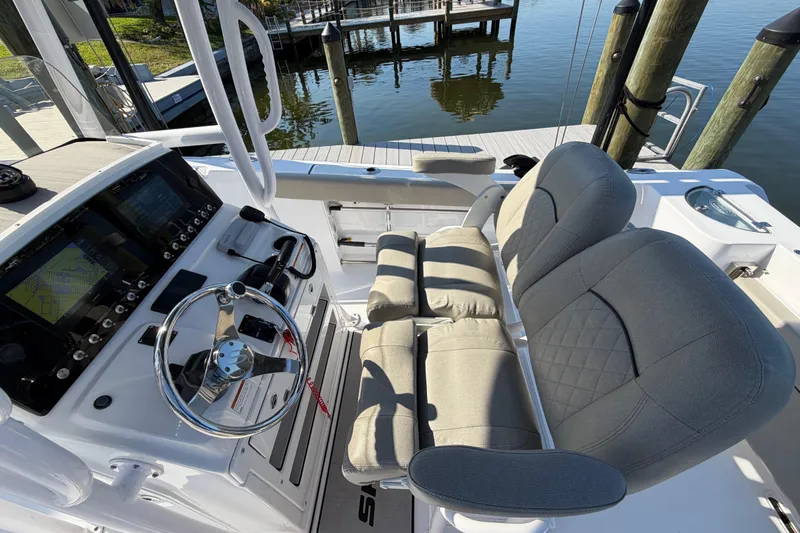 Slide: The Image of 2023 Sportsman Open 232 Center Console boat interior with steering wheel and cushioned seating. - 22