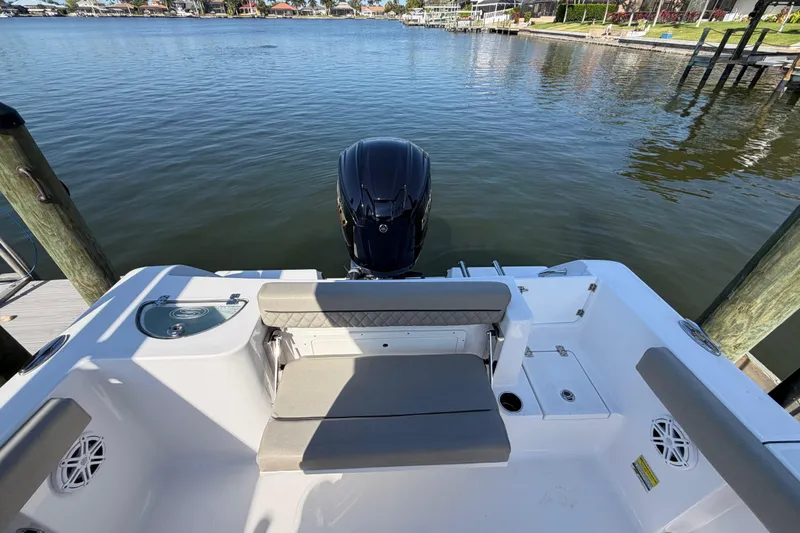 Slide: The Image of 2023 Sportsman Open 232 Center Console boat with seating and outboard motor on calm water. - 27