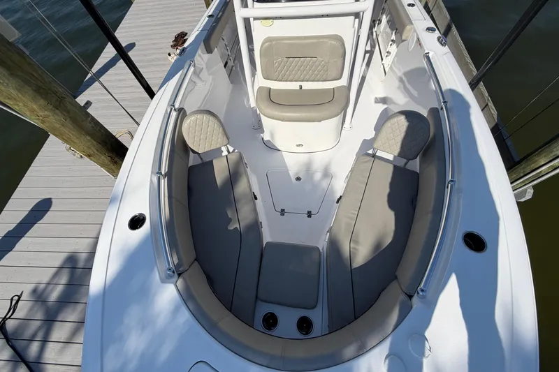Slide: The Image of 2023 Sportsman Open 232 Center Console boat interior with cushioned seating at dock. - 30