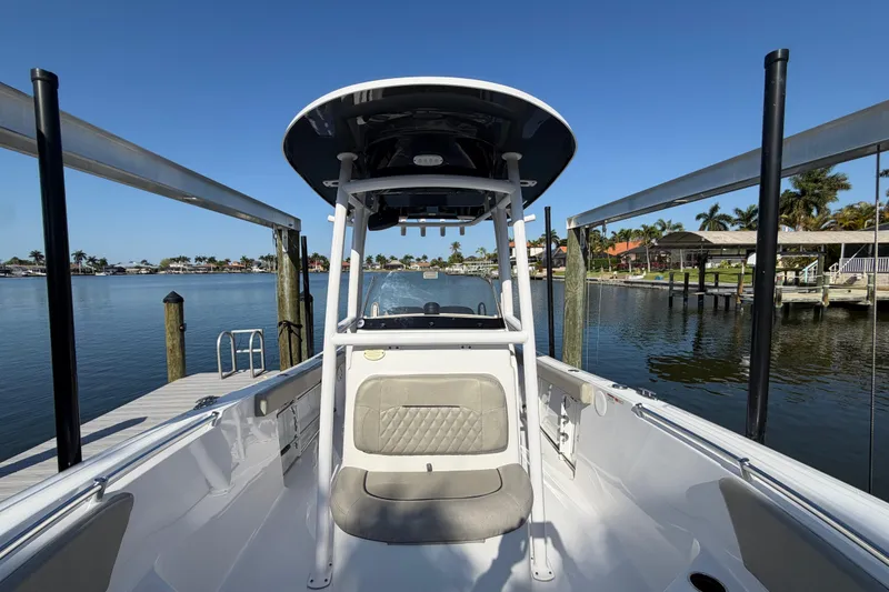 Slide: The Image of 2023 Sportsman Open 232 Center Console boat docked by a scenic waterfront. - 34