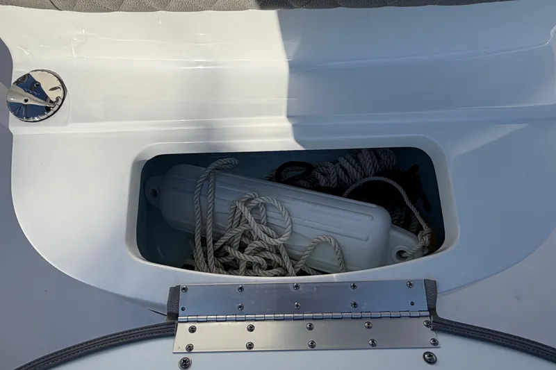Slide: The Image of Storage compartment on 2023 Sportsman Open 232 Center Console with ropes and fender. - 36