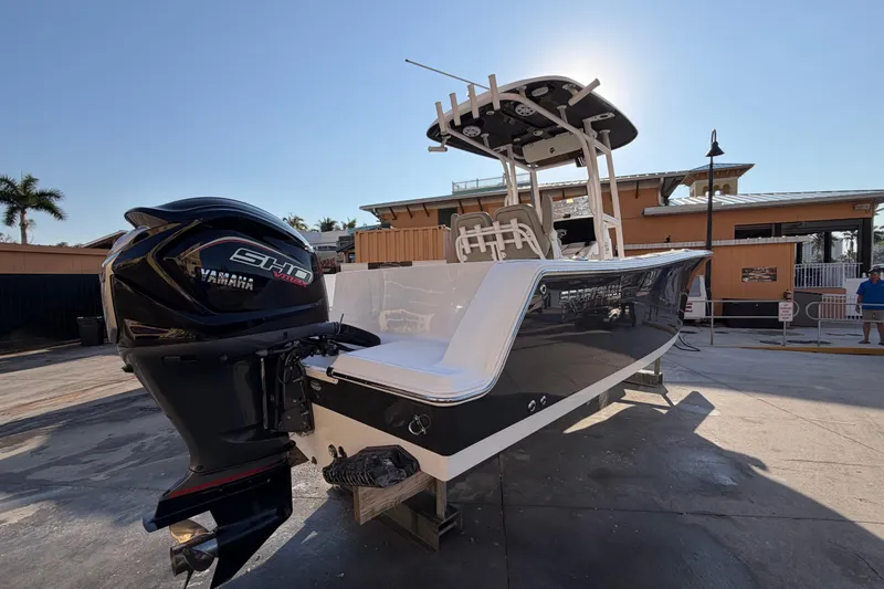 Slide: The Image of 2023 Sportsman Open 232 Center Console boat with Yamaha engine, docked under clear sky. - 4