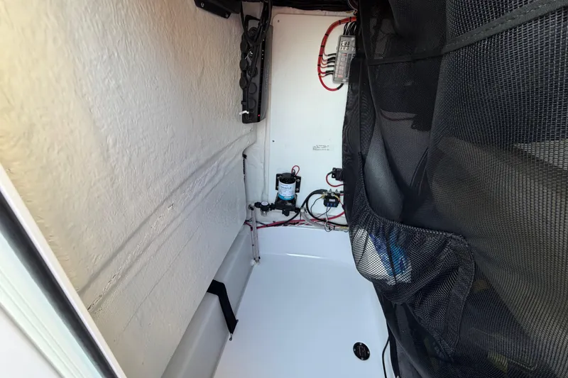 Slide: The Image of 2023 Sportsman Open 232 Center Console interior wiring and storage compartment. - 43