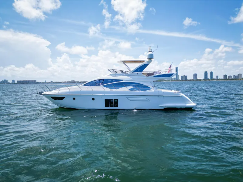 Slide: The Image of 2015 Azimut 54 Fly yacht on open water with city skyline in background. - 19