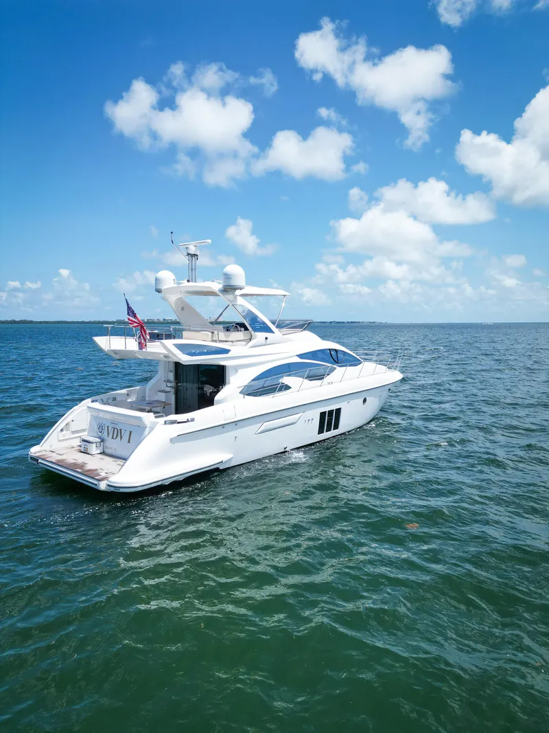 Slide: The Image of 2015 Azimut 54 Fly yacht cruising on open water under a clear blue sky. - 24