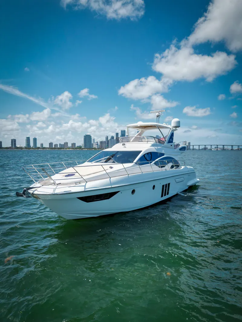 Slide: The Image of 2015 Azimut 54 Fly yacht cruising on a sunny day with city skyline backdrop. - 30