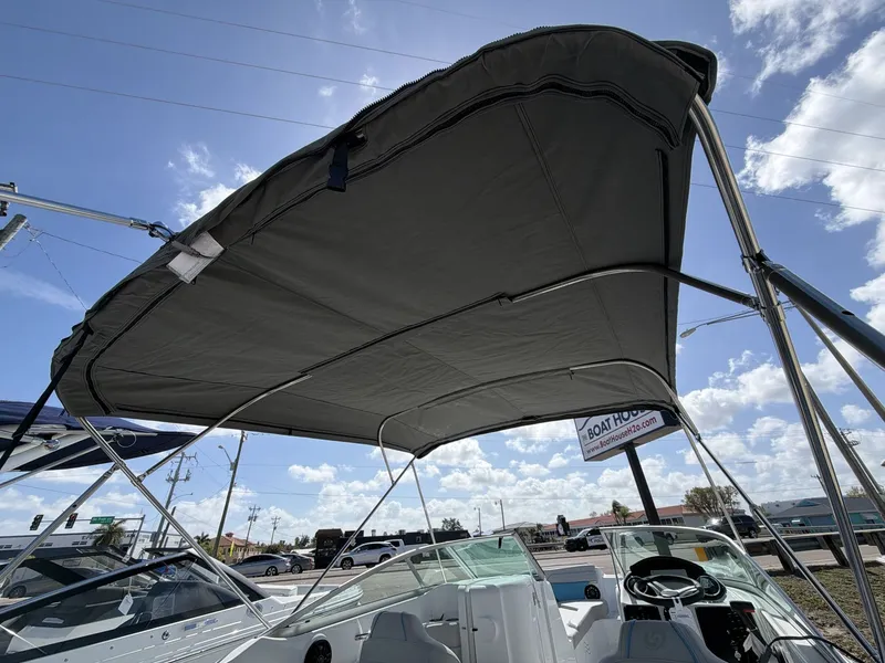 Slide: The Image of Hurricane 2400 SD 2026 boat with canopy, blue sky background. - 12