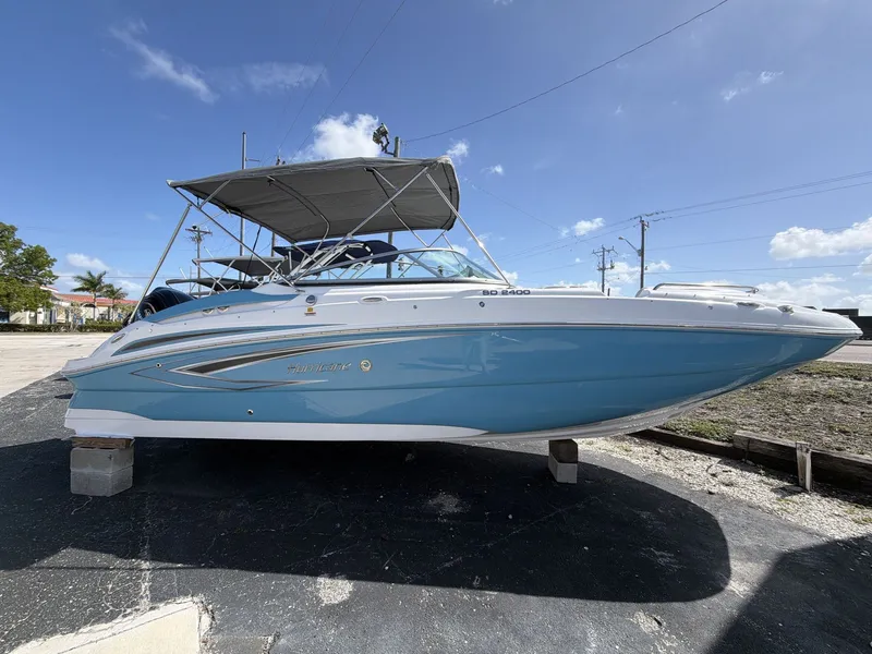 Slide: The Image of 2026 Hurricane 2400 SD boat on a parking lot under sunny skies. - 9