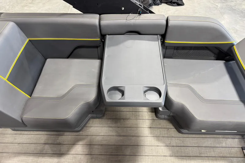 Slide: The Image of Interior seating of 2025 Manitou 24 Explore boat with gray upholstery and yellow accents. - 11