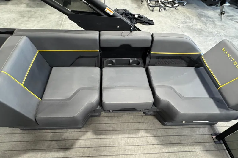 Slide: The Image of 2025 Manitou 24 Explore boat seating with gray upholstery and yellow accents. - 12