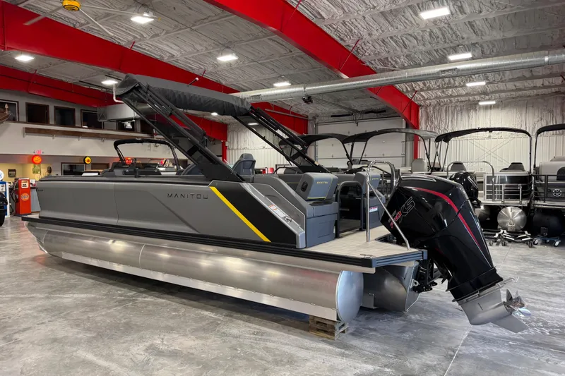 Slide: The Image of 2025 Manitou 24 Explore pontoon boat in showroom, featuring sleek design and powerful engine. - 3