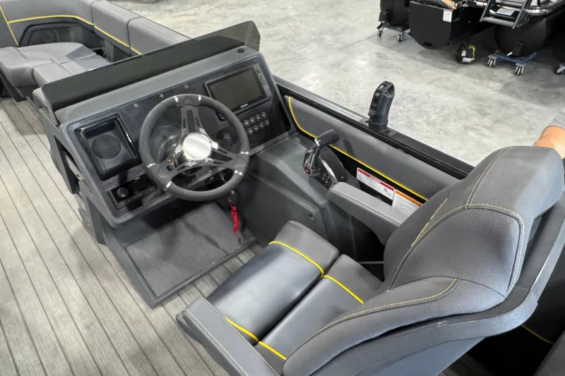 Slide: The Image of Interior view of 2025 Manitou 24 Explore boat cockpit with steering wheel and seating. - 6