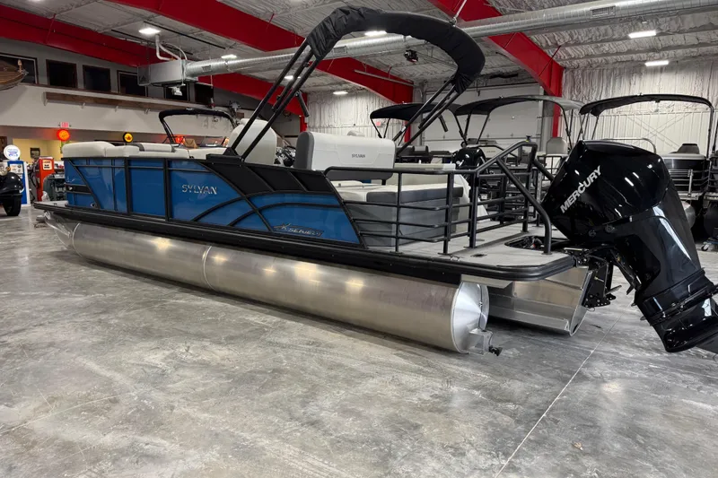 Slide: The Image of 2026 Sylvan Mirage X X5 pontoon boat with Mercury outboard motor in showroom. - 3