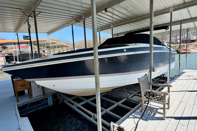 The Image of 2005 Cobalt 282 boat docked under a covered marina on a sunny day. - 0