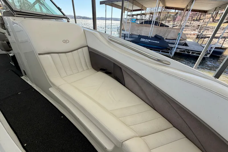 Slide: The Image of 2005 Cobalt 282 boat interior with white seating, docked by the water. - 16