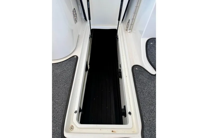 Slide: The Image of Open storage compartment on a 2005 Cobalt 282 boat, featuring a black interior. - 23